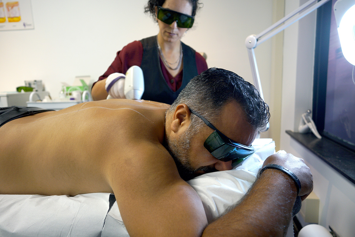 Specialiste behandelt de rug van een man met de Soprano Titanium laser